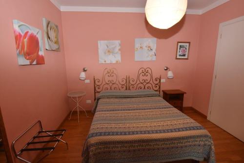a bedroom with a bed in a room with pink walls at Albergo Casa Al Sole in Greve in Chianti
