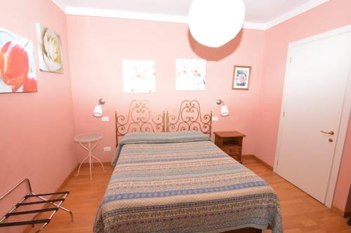 a bedroom with a bed in a room with pink walls at Albergo Casa Al Sole in Greve in Chianti