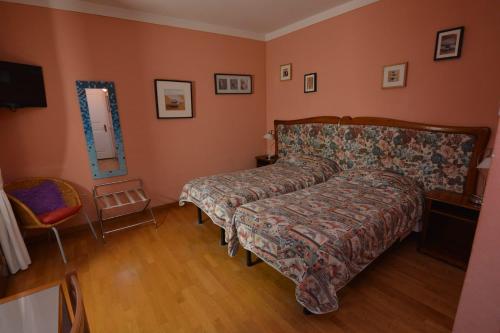 a bedroom with a bed and a chair at Albergo Casa Al Sole in Greve in Chianti
