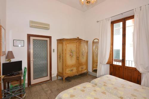 a bedroom with a bed and a dresser and a television at Albergo Casa Al Sole in Greve in Chianti