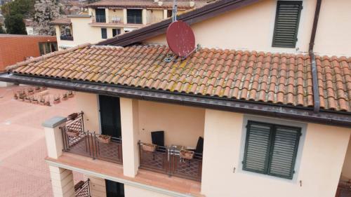 a building with a tile roof and a balcony at Albergo Casa Al Sole in Greve in Chianti