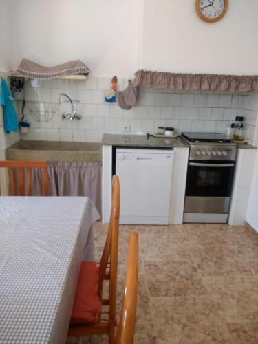 a kitchen with a stove and a table with a tableablish at Casa Rural Masia d'en Gall in L'Aldea