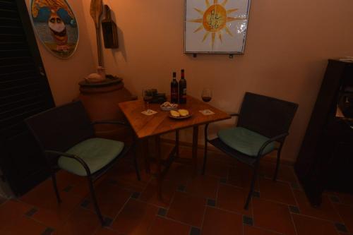 a small table with two chairs and bottles of wine at Albergo Casa Al Sole in Greve in Chianti