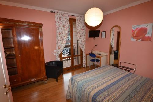 a bedroom with a bed and a desk and a window at Albergo Casa Al Sole in Greve in Chianti