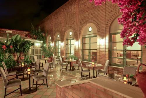 a restaurant with tables and chairs in front of a brick building at Bella Beach Hotel in Hersonissos