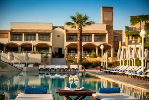 une piscine avec des chaises longues et un hôtel dans l'établissement Bella Beach Hotel, à Chersónissos