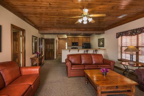 a living room with leather couches and a kitchen at Westgate Branson Woods Resort in Branson
