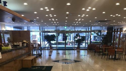 a restaurant with a lobby with tables and chairs at Toyoko Inn Utsunomiya Ekimae No 1 in Utsunomiya