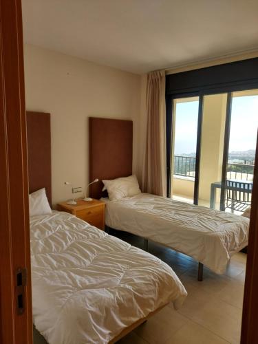 ein Hotelzimmer mit 2 Betten und einem Balkon in der Unterkunft VistaAlta in Marbella