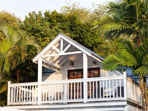 a white house with a porch and palm trees at Nyah - Adult Exclusive in Key West