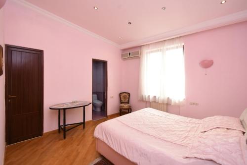 a bedroom with a bed and a table and a window at Guest house YEREVAN in Yerevan