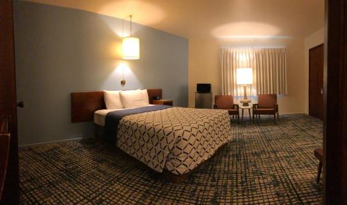 a hotel room with a bed and a table and chairs at Curly Redwood Lodge in Crescent City
