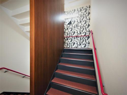 a staircase in a room with a door and a stair railing at Green Rich Hotel Matsue Station Across - Artificial hot spring Futamata Yunohana in Matsue