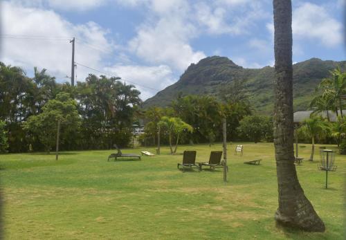 a park with benches and a mountain in the background at The Kauai Inn in Lihue