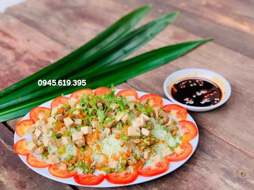 a plate of food with tomatoes and vegetables on a table at BenTrestay in Giồng Tú Ðiền
