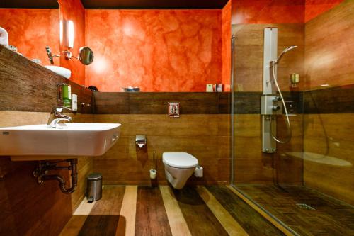 a bathroom with a toilet and a sink and a shower at Landhotel Burg im Spreewald - Resort & Spa in Burg