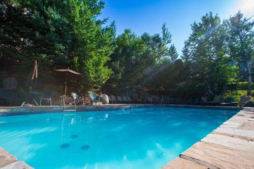 a swimming pool with blue water in a yard at Lodge de la Montagne in Mont-Tremblant
