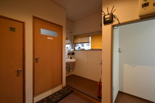 高千穂町にあるゲストハウスいわとの小さなバスルーム(ドア、シンク付)