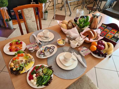 una mesa de madera con platos de comida. en Restauracja Joanna, en Gogolin