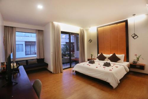 a bedroom with a large bed and a large window at Central Corner Suite in Siem Reap