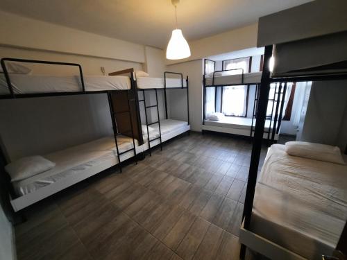 a room with three bunk beds and a wooden floor at Kuyu Beergarden Hostel in Antalya