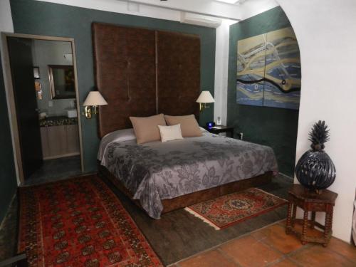 a bedroom with a bed with a large headboard at La Casa del Atrio in Querétaro