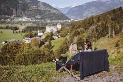 two women sitting at a table on a hill at Panorama Hotel Guggenbichl - inkl Sommerkarte, einmaliger Eintritt ins Tauern Spa & bester Ausblick über Kaprun in Kaprun