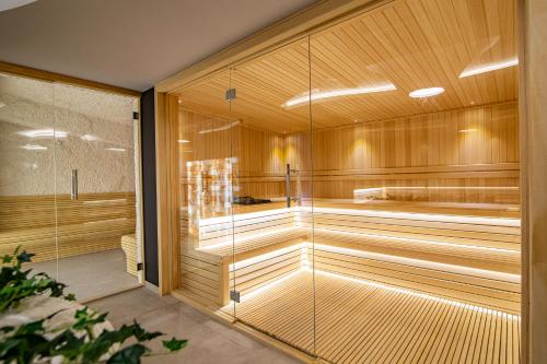 a sauna with wooden walls and a glass door at Titova Vila Zlatibor in Zlatibor
