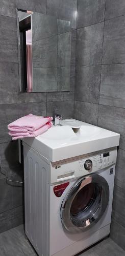 a washing machine with a sink and a mirror at 1 кк люкс лофт студия in Mykolaiv