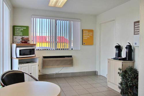 a kitchen with a table and a microwave and a window at Motel 6-Fargo, ND - West Acres - North Fargo in Fargo