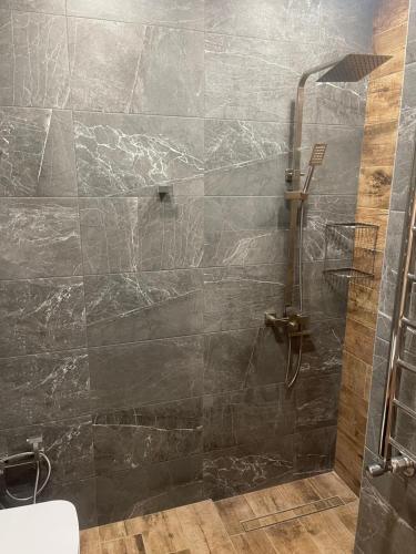 um banheiro com chuveiro e parede de pedra em Cozy Apartment With The Best Patio and Swimming pool em Yerevan