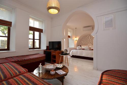 uma sala de estar com uma cama, um sofá e uma mesa em Amina Hanem Boutique Apartments em Cavala