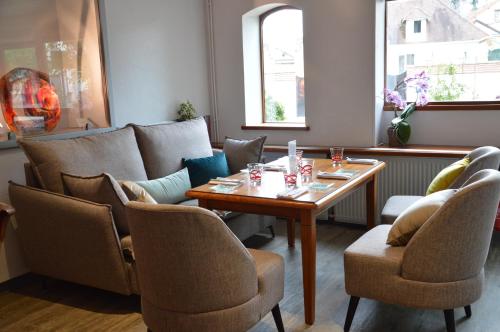 a room with a table and chairs and a couch at Nicey - Hôtel Spa, Lounge, Coworking in Romilly-sur-Seine