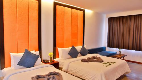 a hotel room with two beds with hats on them at Central Corner Suite in Siem Reap