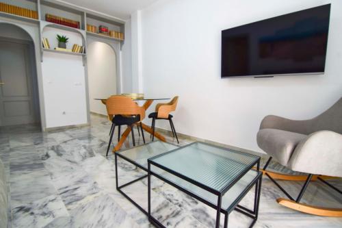 sala de estar con mesa, sillas y TV en Letmalaga Reding, en Málaga