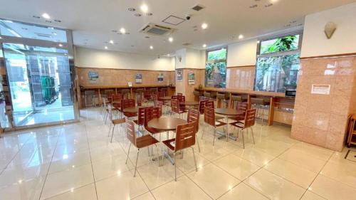 a dining room with tables and chairs and windows at Toyoko Inn Yokohama Shinkoyasu Ekimae in Yokohama