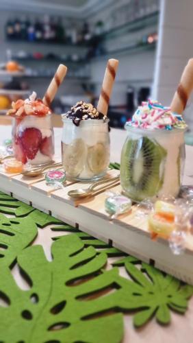 three desserts in jars on a table with forks at Residence Margherita in Cattolica