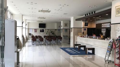 eine Lobby mit einem Restaurant mit Tischen und Stühlen in der Unterkunft Toyoko Inn Keio sen Hashimoto eki Kita guchi in Sagamihara