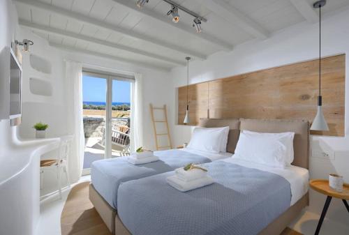 two beds in a bedroom with a view of the ocean at Beachfront Villa Kalafatis by Aesthia Estate in Kalafatis