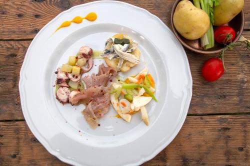 a plate of food with meat and vegetables on a table at Agriturismo Masseria Cannella in Lesina
