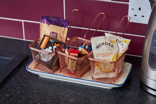 a tray with four baskets on top of a counter at Delven House- Serviced Apartments in Castle Donington