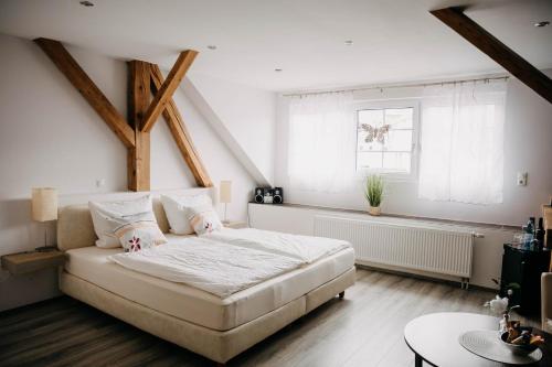 a bedroom with a large white bed and a window at Altstadt-Residenz Manz in Wachenheim an der Weinstraße