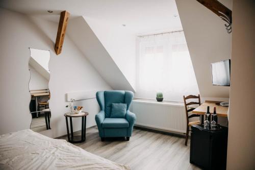 Un dormitorio con una silla azul y una cama en Altstadt-Residenz Manz, en Wachenheim an der Weinstrasse