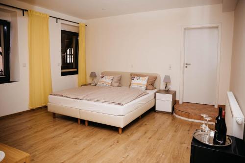 a bedroom with a white bed and wooden floors at Altstadt-Residenz Manz in Wachenheim an der Weinstraße