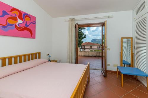 a bedroom with a bed and a door to a balcony at Erica Piano Terra & Erica Primo Piano in Golfo Aranci