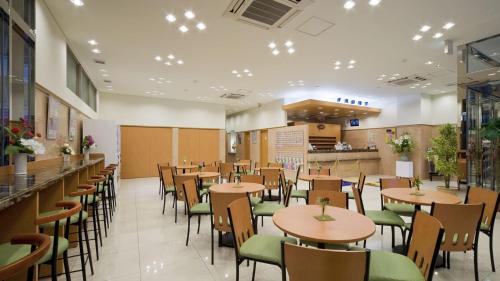 a restaurant with tables and chairs and a counter at Toyoko Inn Yokohama Tsurumi eki Higashi guchi in Yokohama
