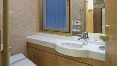 a bathroom with a sink and a mirror at Toyoko Inn Yokohama Tsurumi eki Higashi guchi in Yokohama