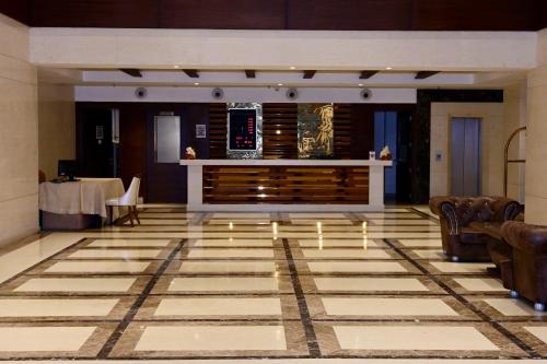 a lobby with a bar and a table with chairs at HOTEL LANDMARK ROYALE, LAKHIMPUR in Lakhīmpur