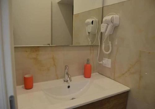 uma casa de banho com um lavatório e um telefone na parede em Locazione turistica Totaro em Vico del Gargano