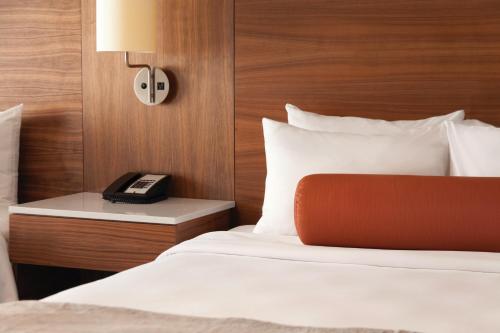 a hotel room with a bed with a phone on it at Radisson Hotel & Conference Centre Calgary Airport in Calgary